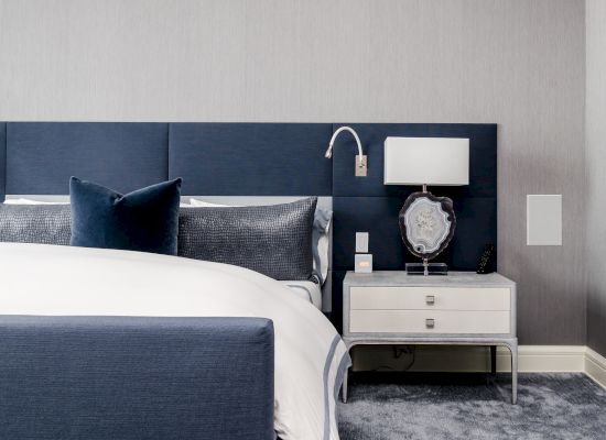 Elegant bedroom with a blue and white theme, modern furnishings, and decorative items