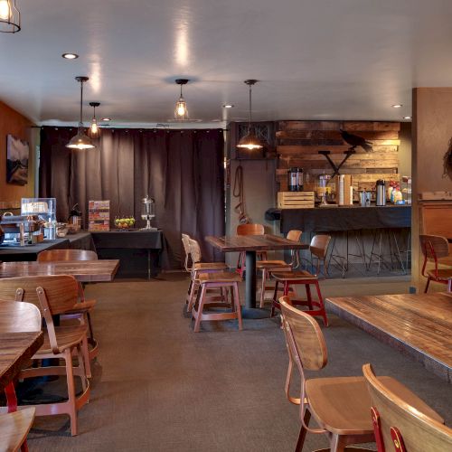 The image shows a cozy, rustic-style cafe with wooden tables and chairs, pendant lighting, and western decor, including lassos and hats on the walls.